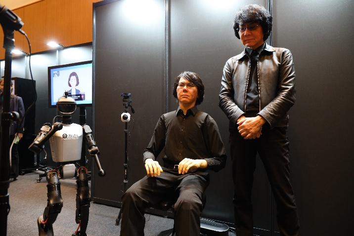 特別展示でロボットと記念撮影をする石黒浩氏の様子